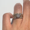 Gold rings with diamond stacked on a finger against a white background